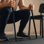 Gym avec un elastique : squat du corps avec bande élastique